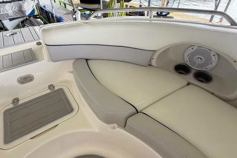 Slide: The Image of Interior of a 2010 Bryant 255 boat featuring cushioned seating and built-in speakers. - 30