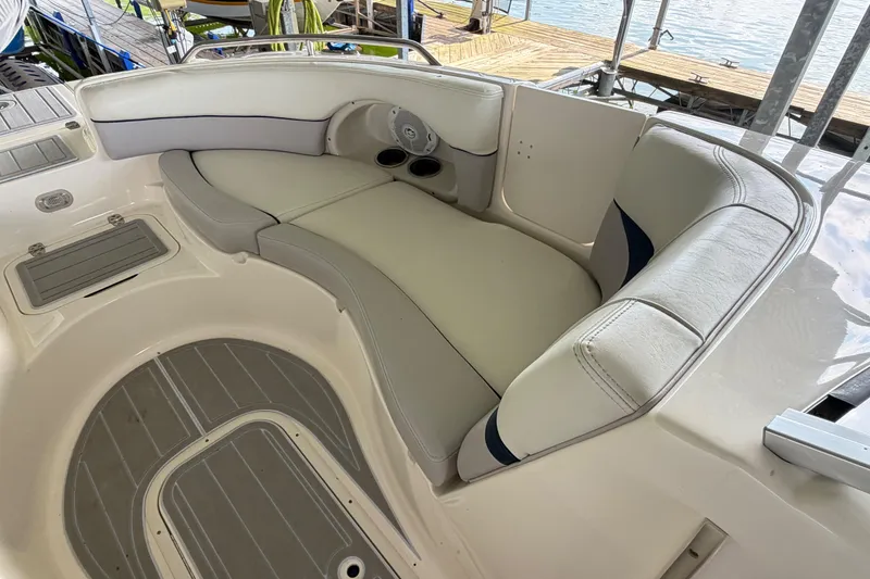 Slide: The Image of Luxurious seating area on a 2010 Bryant 255 boat, featuring comfortable white upholstery. - 32
