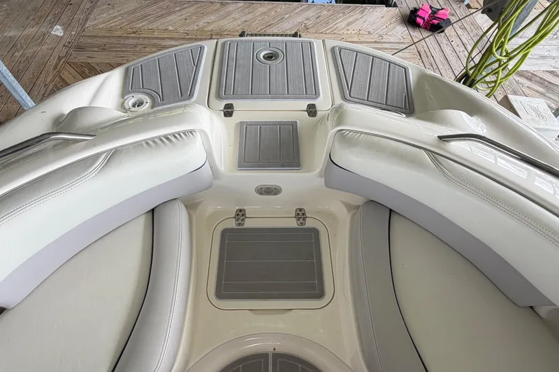 Slide: The Image of Interior view of a 2010 Bryant 255 boat with cushioned seating and deck storage. - 33