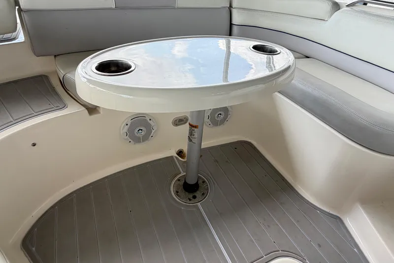 Slide: The Image of Interior of a 2010 Bryant 255 boat featuring a table with cup holders. - 38