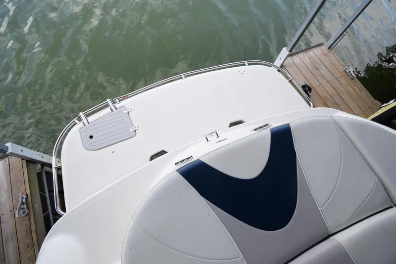 Slide: The Image of The image shows the stern of a 2010 Bryant 255 boat docked at a pier. - 45