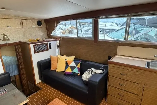 Slide: The Image of Interior of 1980 Chris-Craft 381 Catalina yacht with sofa, colorful pillows, and kitchenette. - 19