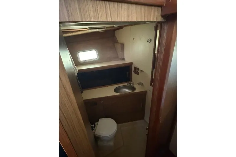 Slide: The Image of 1980 Chris-Craft 381 Catalina yacht bathroom with sink, toilet, and window. - 21
