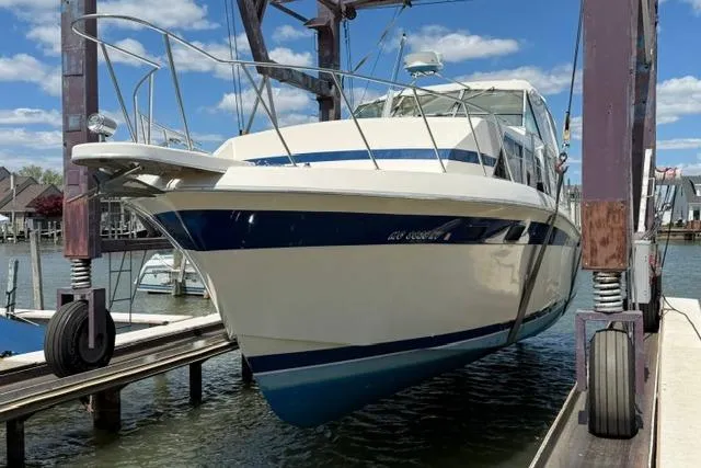 Slide: The Image of 1980 Chris-Craft 381 Catalina yacht on lift, dockside, under blue sky. - 4