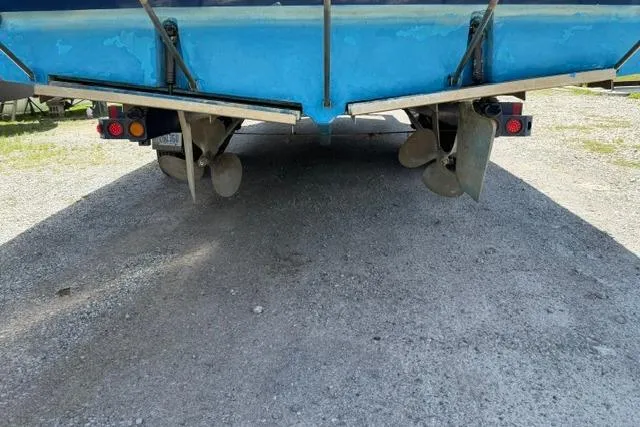 Slide: The Image of 1980 Chris-Craft 381 Catalina boat underside with dual propellers on gravel surface. - 7