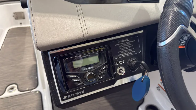 Slide: The Image of The image shows the dashboard of a Four Winns HD5 boat with a Kicker audio system. - 23