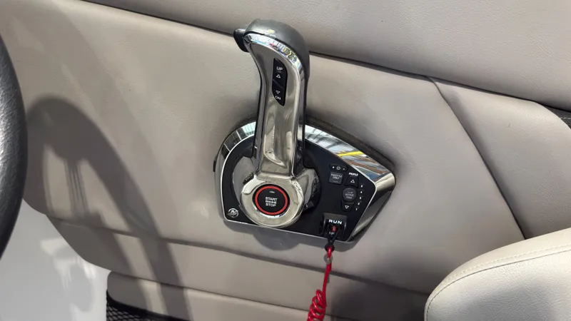 Slide: The Image of Close-up of the throttle lever on a 2022 Four Winns HD5 boat, featuring a start button and safety lanyard. - 28