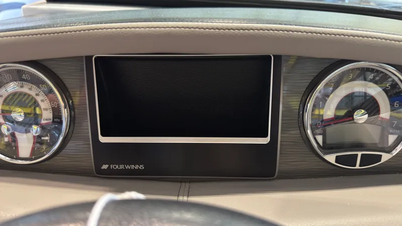 Slide: The Image of Dashboard of a 2022 Four Winns HD5 boat with gauges and a screen. - 25