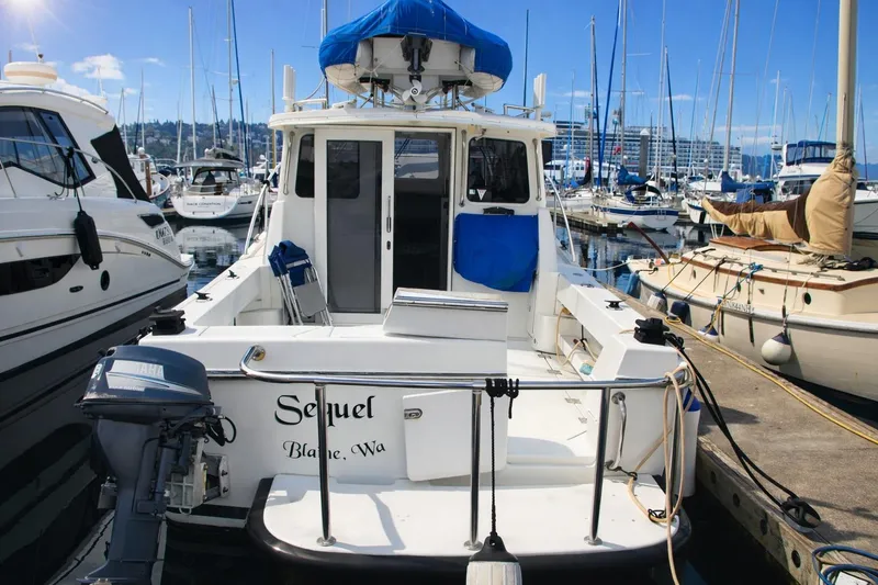 Slide: The Image of 2005 Ocean Sport 30' boat docked at marina, surrounded by other vessels. - 7