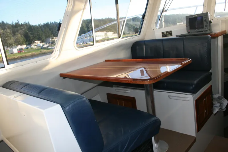 Slide: The Image of Interior of a 2005 Ocean Sport 30' boat with seating and a wooden table. - 10