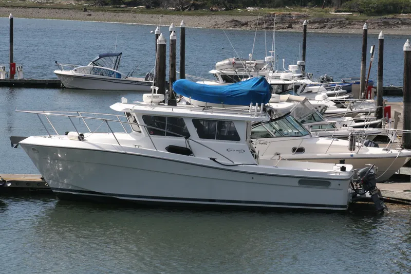 Slide: The Image of 2005 Ocean Sport 30' boat docked at marina, surrounded by other vessels. - 1