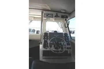 Slide: The Image of 2005 Ocean Sport Roamer 30' boat cockpit with steering wheel and control panel. - 9