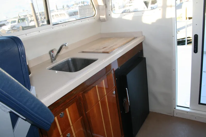 Slide: The Image of Interior of 2005 Ocean Sport 30' boat with sink, countertop, and wooden cabinets. - 12