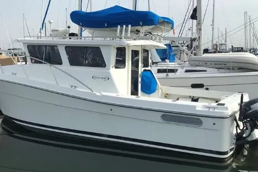 Slide: The Image of 2005 Ocean Sport 30' boat docked in marina, featuring blue canopy and sleek design. - 4