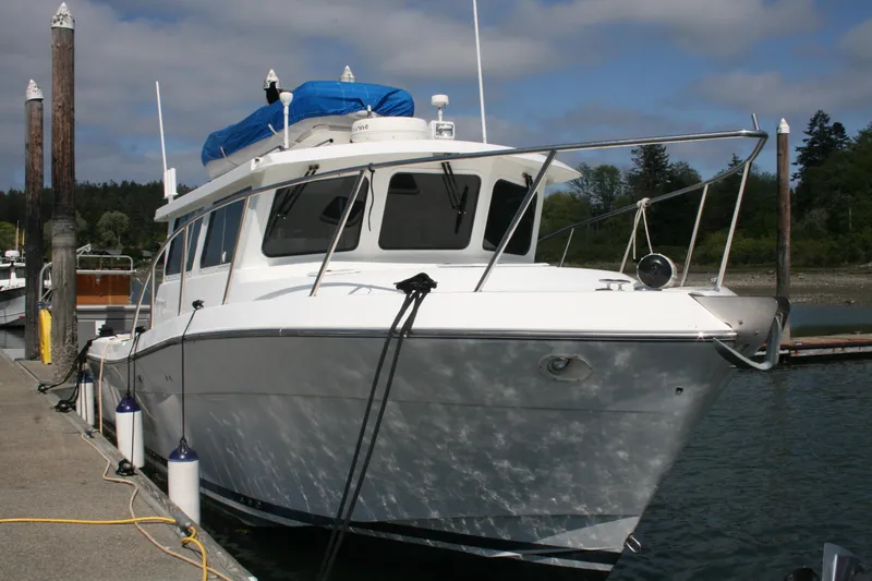 Slide: The Image of 2005 Ocean Sport 30' boat docked at marina under cloudy sky. - 3