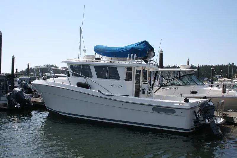 Slide: The Image of 2005 Ocean Sport 30' boat docked at marina, featuring sleek design and covered upper deck. - 2