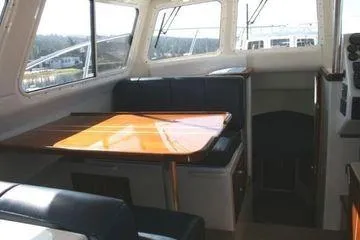 Slide: The Image of 2005 Ocean Sport Roamer 30' interior with seating and table, showcasing cabin design. - 11