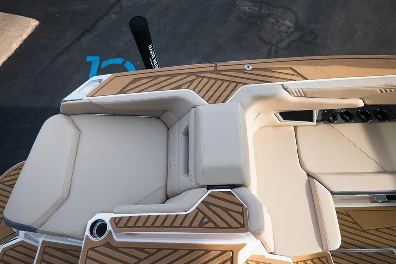 Slide: The Image of 2026 MasterCraft XStar 23 boat interior with beige seating and stylish wood accents. - 13
