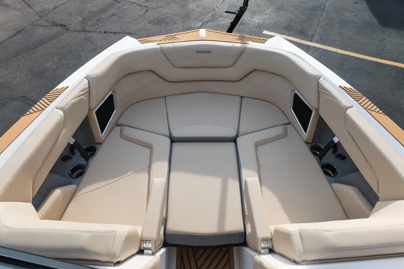 Slide: The Image of 2026 MasterCraft XStar 23 boat interior with beige seating and cup holders. - 24