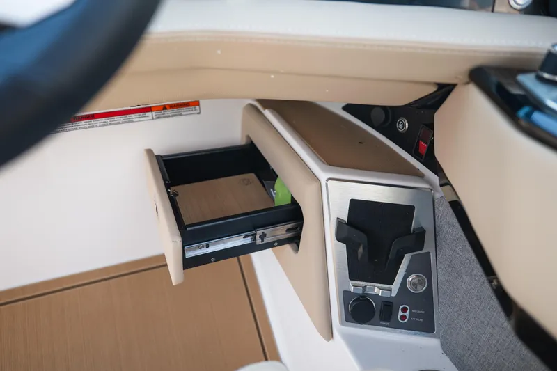 Slide: The Image of Interior view of 2026 MasterCraft XStar 23 boat dashboard with open storage compartment. - 29