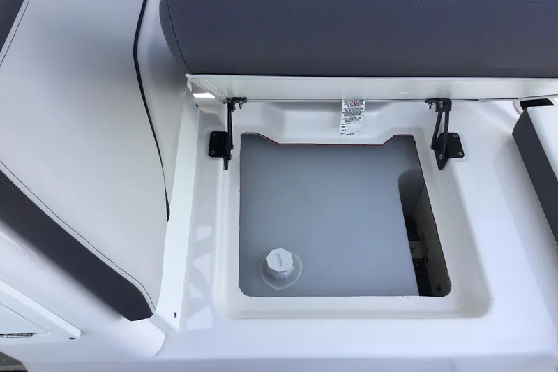 Slide: The Image of 2023 Yamaha Boats 252XE storage compartment with open seat revealing interior space. - 24