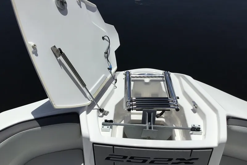 Slide: The Image of 2023 Yamaha Boats 252XE bow storage with ladder and anchor compartment open. - 15