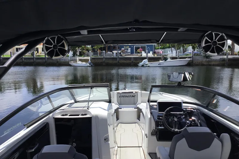 Slide: The Image of 2023 Yamaha Boats 252XE interior view, featuring sleek design and advanced controls on a calm waterway. - 34