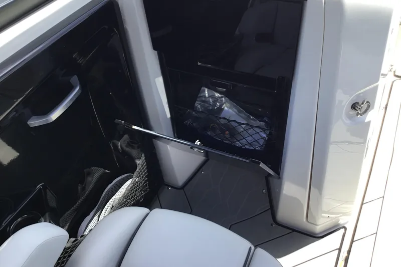 Slide: The Image of 2023 Yamaha Boats 252XE interior storage compartment with open door and seating. - 29