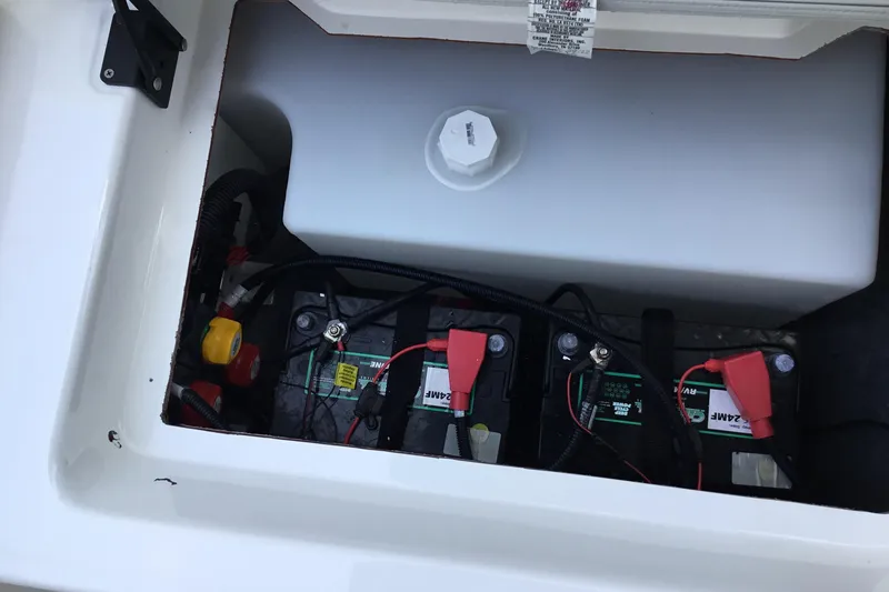 Slide: The Image of 2023 Yamaha Boats 252XE battery compartment with dual batteries and wiring. - 23