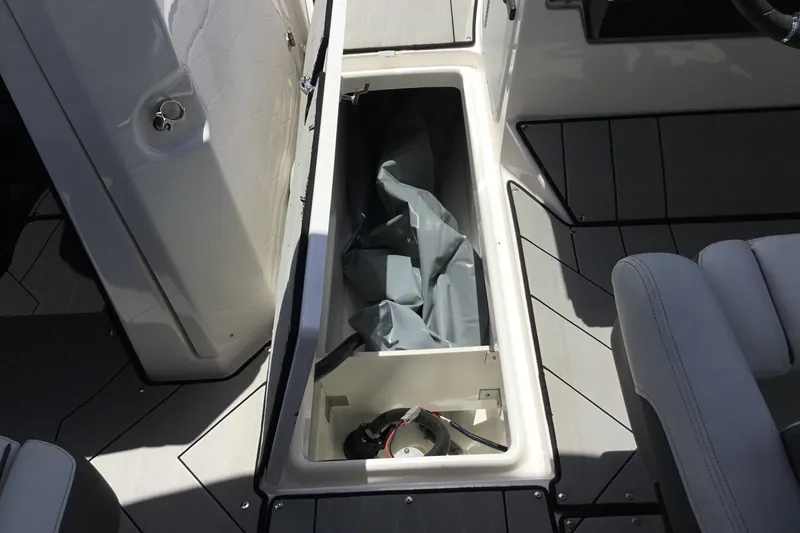Slide: The Image of 2023 Yamaha Boats 252XE storage compartment with open hatch, showcasing interior space. - 26