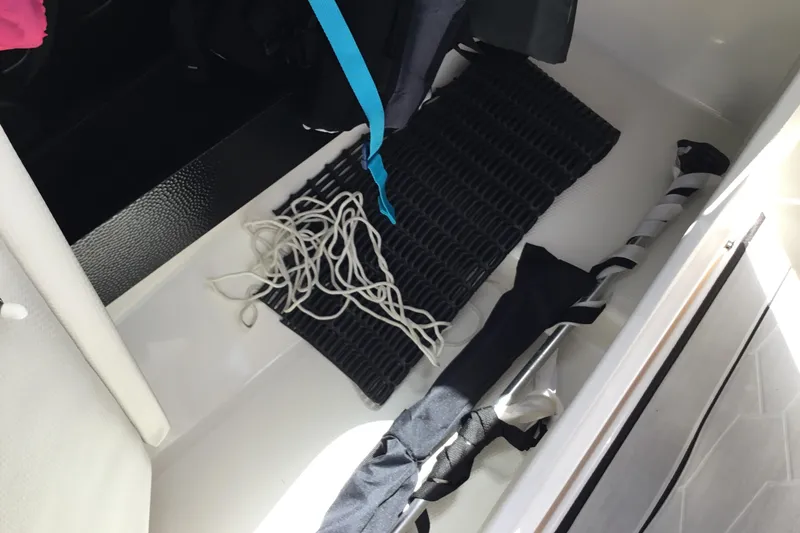 Slide: The Image of Storage compartment of 2023 Yamaha Boats 252XE with rope and equipment. - 28