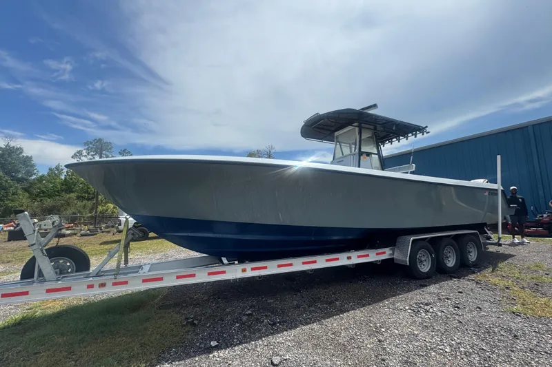 The Image of 2007 Contender 33 Tournament boat on trailer, parked outdoors under a cloudy sky. - 0