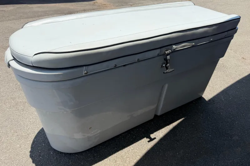 Slide: The Image of 2007 Contender 33 Tournament boat storage compartment with cushioned lid on pavement. - 30