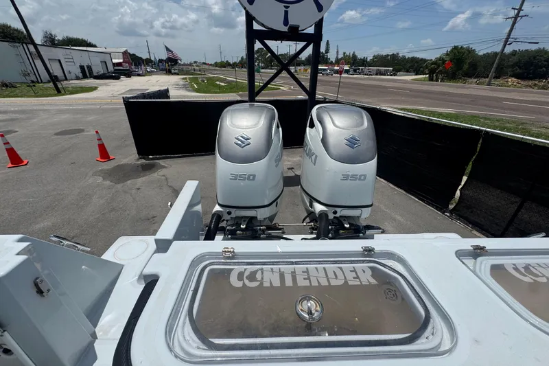 Slide: The Image of 2007 Contender 33 Tournament boat with dual Suzuki 350 outboard engines in a parking lot. - 68