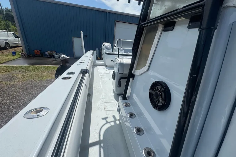 Slide: The Image of 2007 Contender 33 Tournament boat interior with rod holders and speaker, parked near blue building. - 19