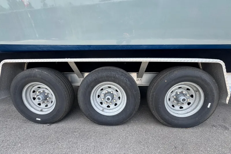 Slide: The Image of Trailer wheels of a 2007 Contender 33 Tournament boat on pavement. - 78