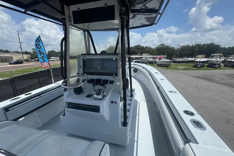 Slide: The Image of 2007 Contender 33 Tournament boat interior with steering console and seating, parked outdoors. - 27