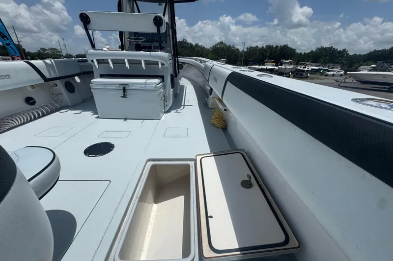 Slide: The Image of 2007 Contender 33 Tournament boat deck with storage compartments and seating under a sunny sky. - 23