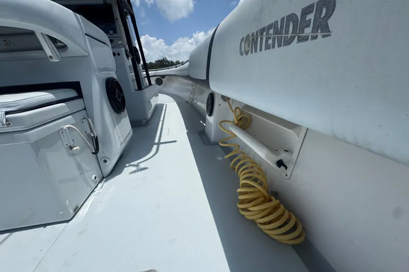 Slide: The Image of 2007 Contender 33 Tournament boat interior with seating and coiled hose under a blue sky. - 25