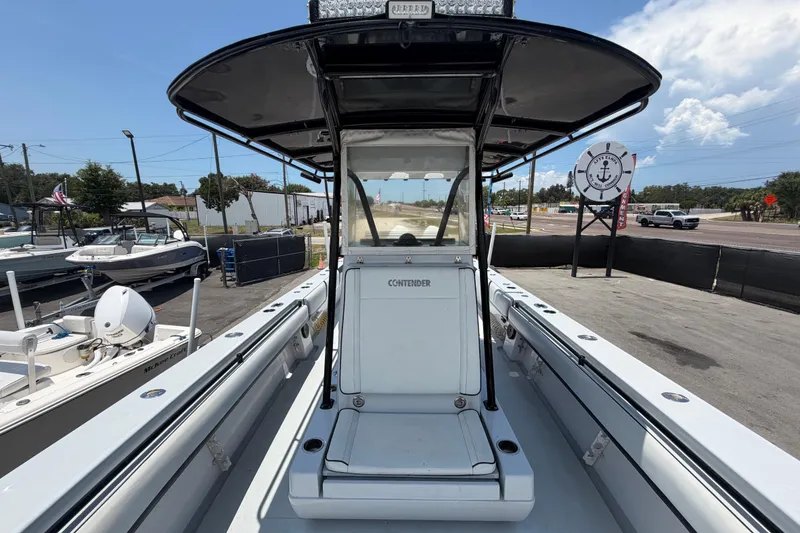 Slide: The Image of 2007 Contender 33 Tournament boat with T-top, docked at a marina under a clear sky. - 23
