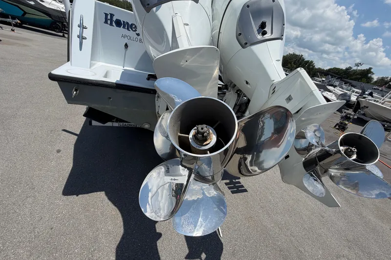 Slide: The Image of 2007 Contender 33 Tournament boat with shiny propellers, parked on a sunny day. - 5
