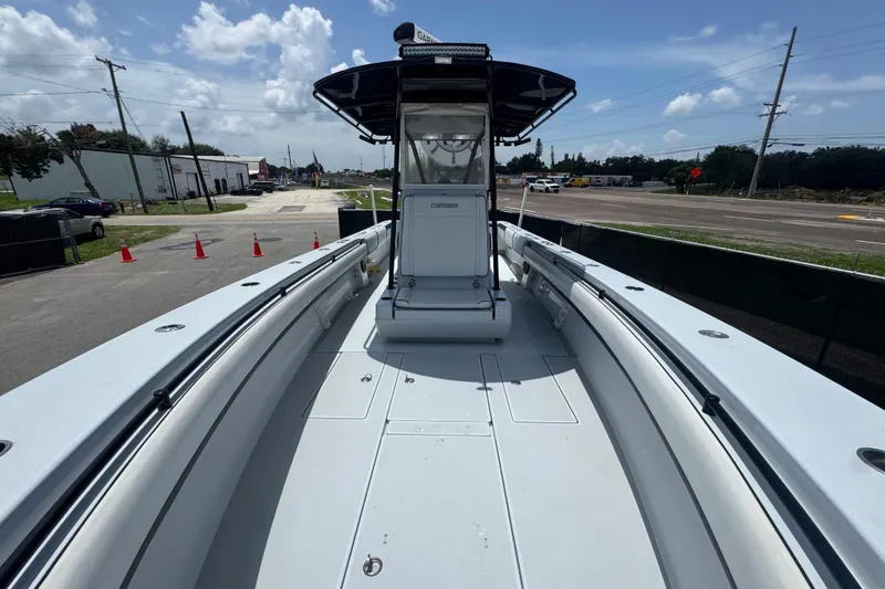 Slide: The Image of 2007 Contender 33 Tournament boat, spacious deck, clear sky, parked on roadside. - 45
