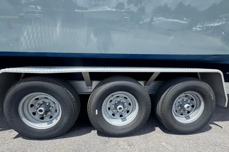 Slide: The Image of Trailer wheels of a 2007 Contender 33 Tournament boat on asphalt. - 80