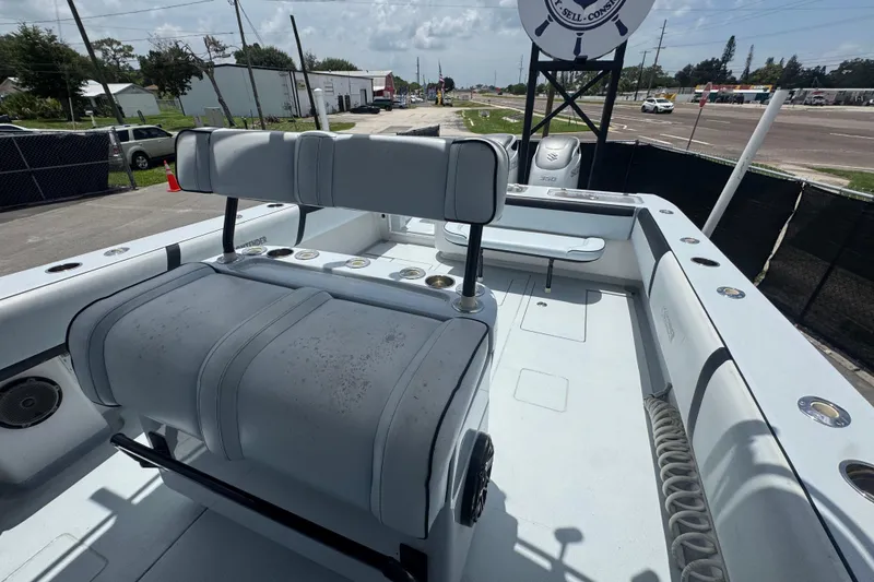 Slide: The Image of 2007 Contender 33 Tournament boat interior with seating and rod holders, parked outdoors. - 60