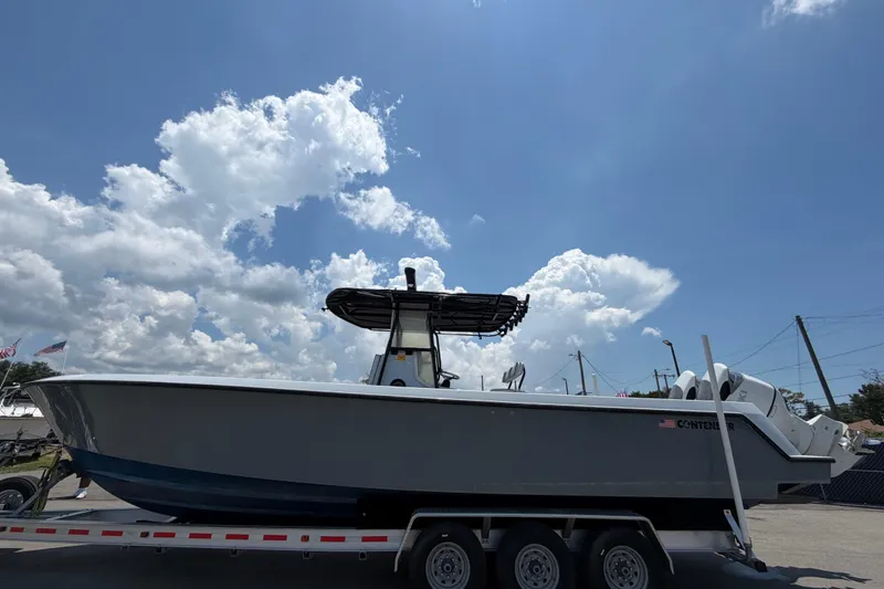 Slide: The Image of A 2007 Contender 33 Tournament boat on a trailer under a cloudy sky. - 1