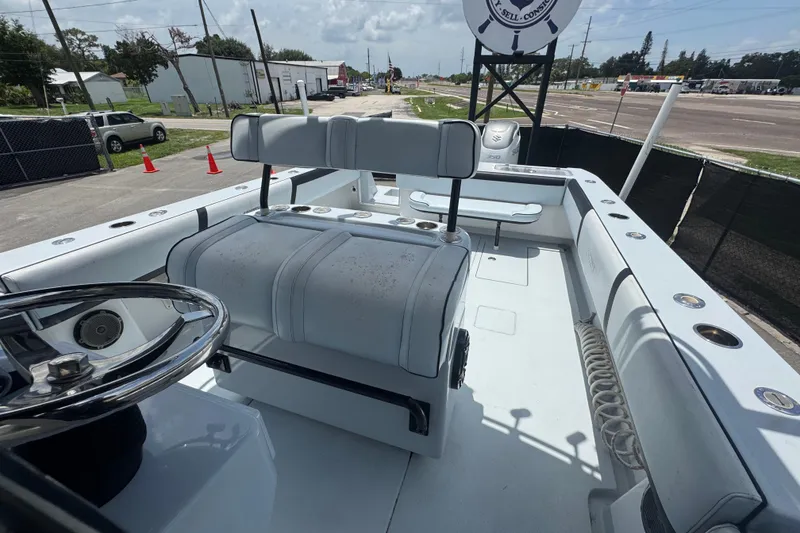 Slide: The Image of 2007 Contender 33 Tournament boat interior with seating and steering wheel, docked outdoors. - 59