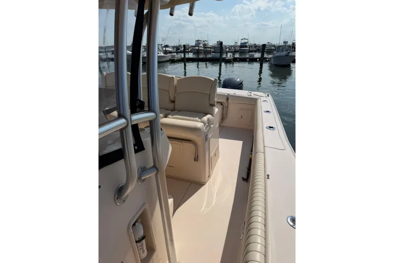 Slide: The Image of 2008 Grady-White Canyon 336 boat interior at marina, showcasing seating and railing. - 8