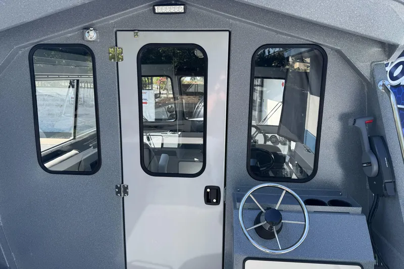 Slide: The Image of Interior view of 2027 KingFisher 2025 Escape HT boat, featuring steering wheel and cabin door. - 20
