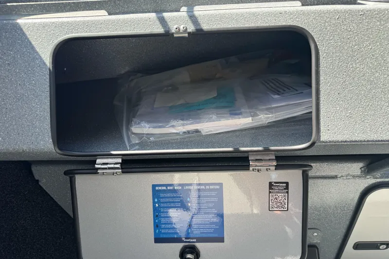 Slide: The Image of Open storage compartment in a 2027 KingFisher 2025 Escape HT boat, containing documents. - 34