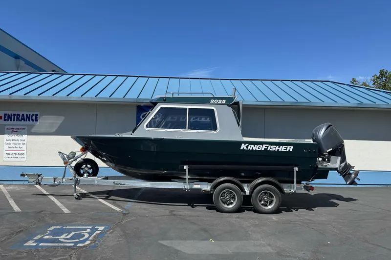 The Image of KingFisher 2025 Escape HT boat on trailer, parked outside a building, sunny day. - 2